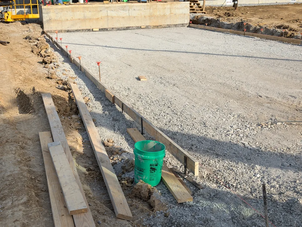 Slab forms set on a graded base in front of a new commercial building, commercial concrete