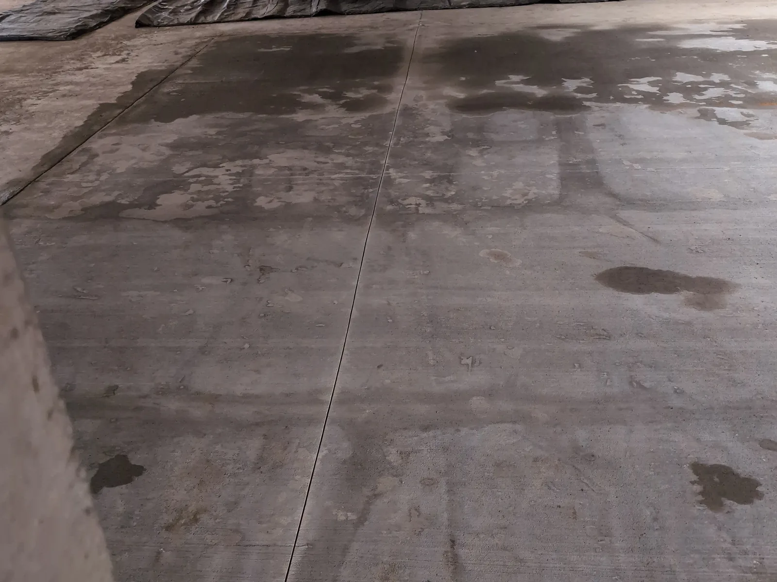 New concrete slab under a commercial building with barrels around the work area, commercial concrete