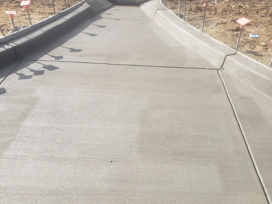 Long new concrete driveway climbing a wooded slope, concrete driveways