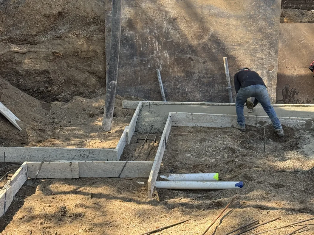 Wood footing forms with rebar dowels in an excavated foundation, concrete foundations