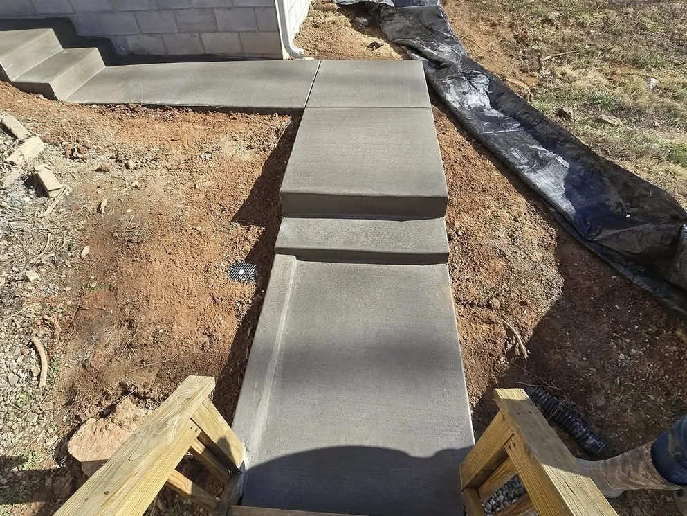 New concrete steps running down the side yard of a house, concrete steps
