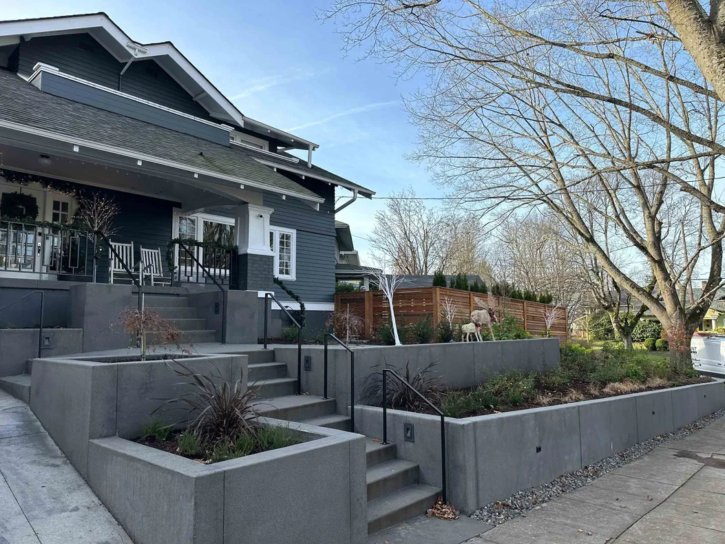 Board formed poured concrete retaining walls and steps in front of a house, concrete retaining walls
